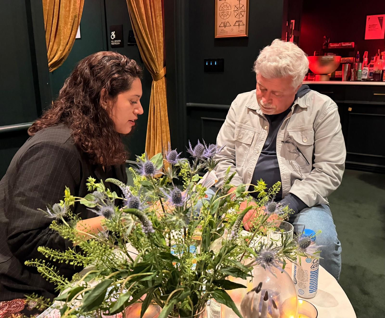 Kaide reading cards for a guest at an event table set with fresh flowers